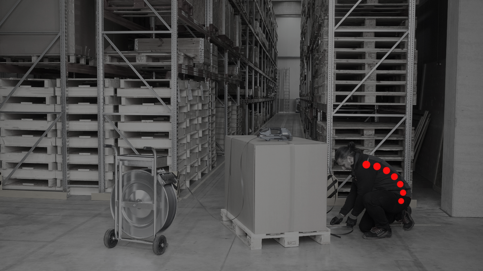 Ergonomic strapping machine - pallet securing with ErgoPack Strapping a pallet with a roll-off trolley. The curved position of the spine is marked in red.